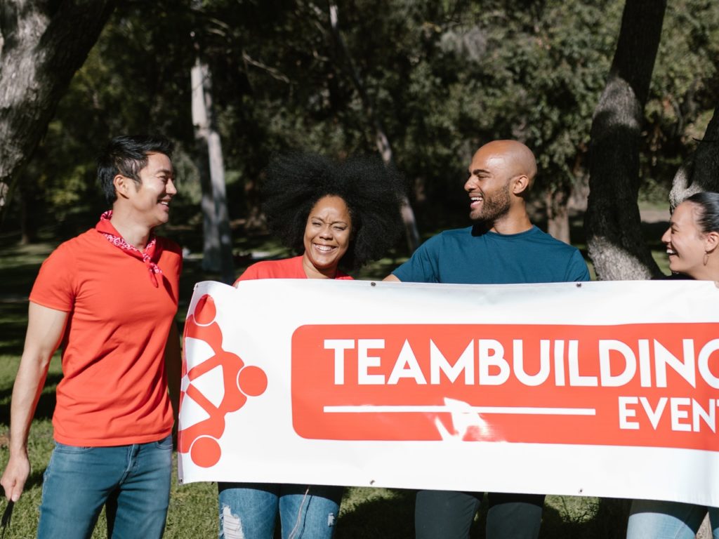 Team holding team building event sign